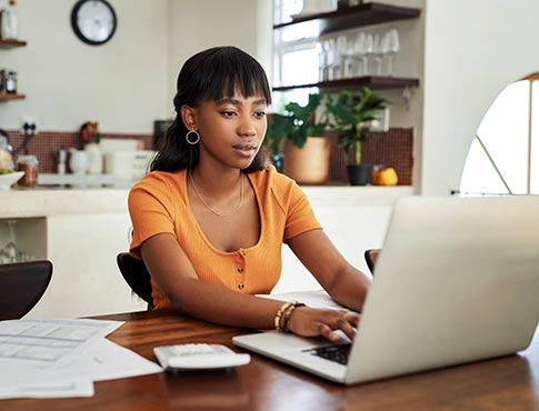 Young woman using laptop at home.