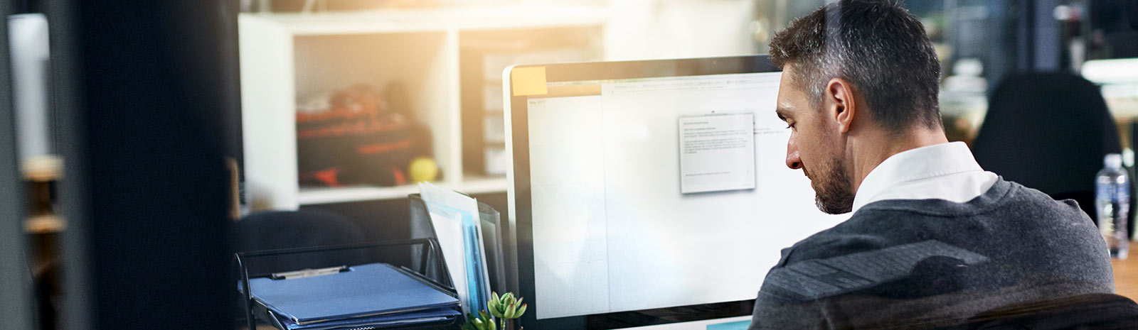 Man sitting at desk and computer in an office.