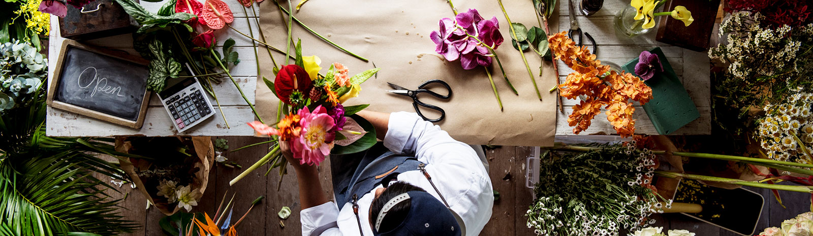 Employee putting together bouquet of flowers.