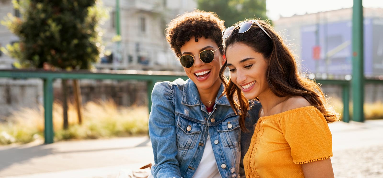 Two friends smiling outdoors.