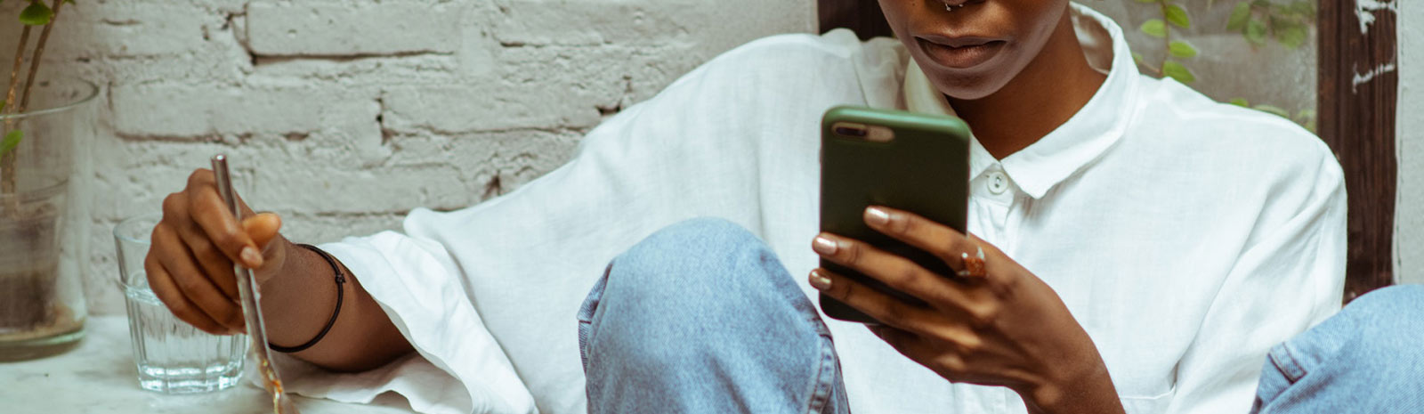 Woman holding phone at table.