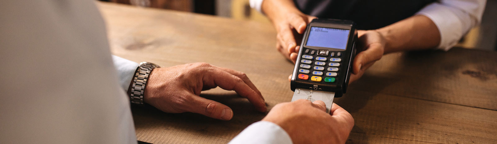 Man paying with card at store counter.