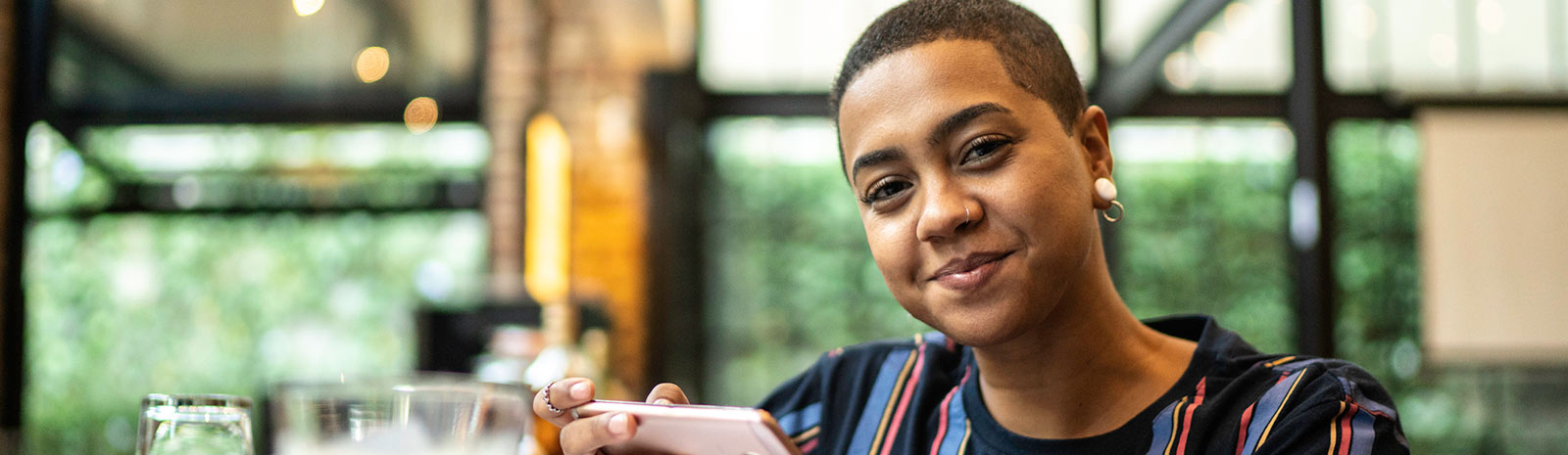 Woman holding phone in cafe.